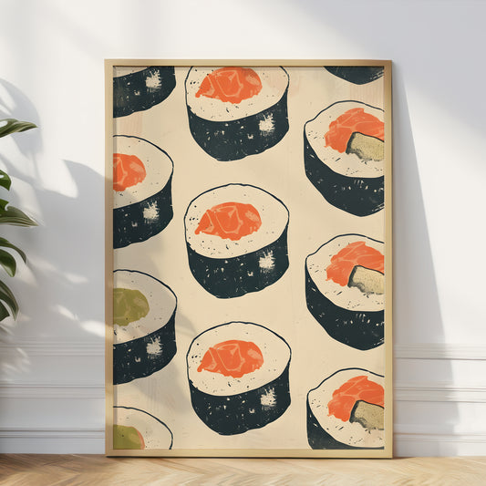 A framed art print featuring a retro pattern of sushi maki rolls on a cream background, leaning against a white wall on a wooden floor next to a green plant.