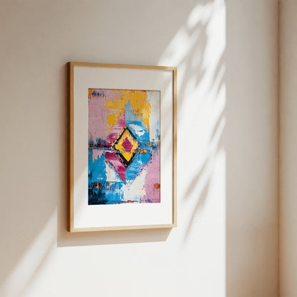 A framed abstract art print with a colorful geometric diamond design, hanging on a warm beige wall with soft sunlight and leaf shadows cast across it.