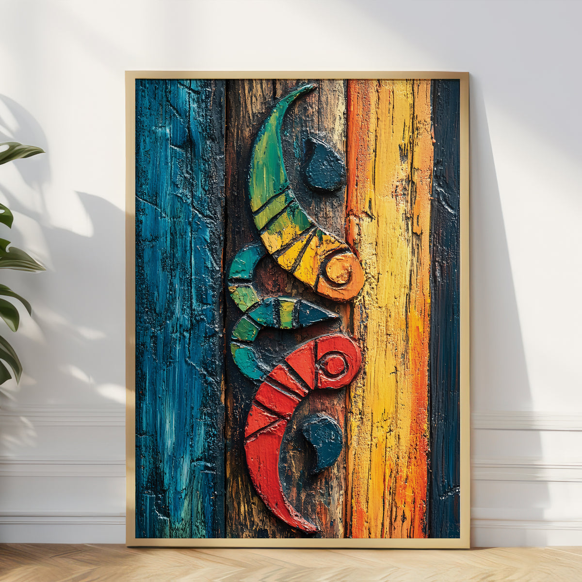 A framed abstract art print featuring a stylized floral ornament in bold red, yellow, blue, black, and white brushstrokes, leaning against a white wall on a light wood floor with a plant visible at the left edge.