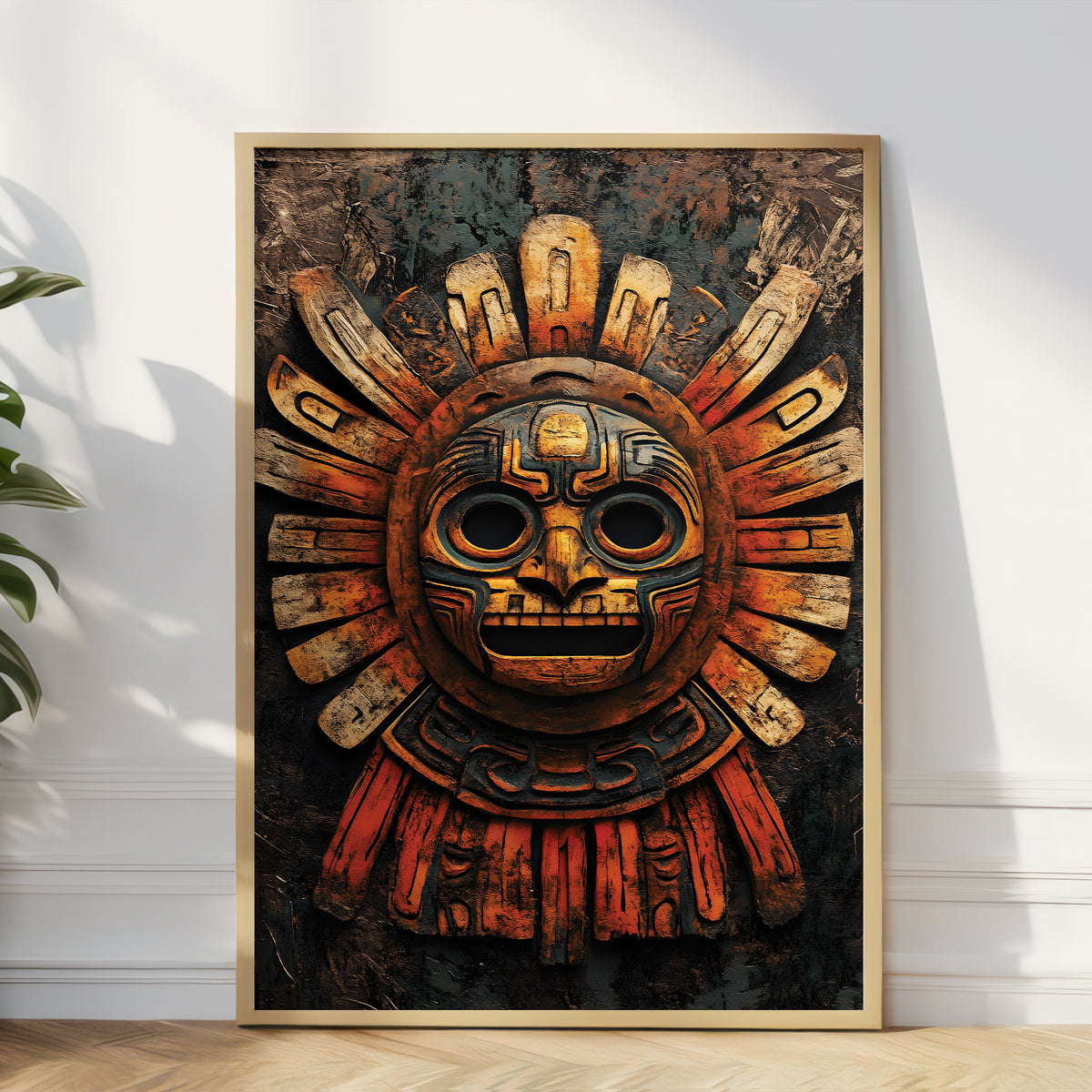 A framed art print featuring a detailed Aztec-style sun mask, leaning against a white wall on a light wood floor next to a green plant.