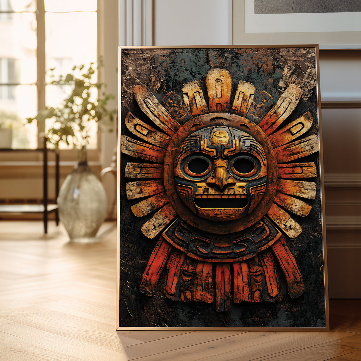 A framed art print featuring a detailed Aztec sun mask, leaning against a wall on a light wood floor in a bright, modern room.