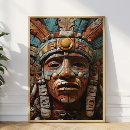 A large framed art print featuring a detailed Aztec-style face with a feathered headdress, leaning against a white wall on a light wood floor next to a green plant.