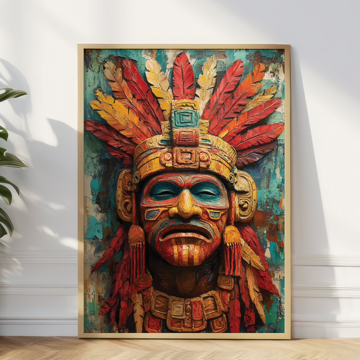 A framed art print featuring a detailed Aztec-style warrior mask with a large feathered headdress, leaning against a white wall on a light wood floor next to a green plant.