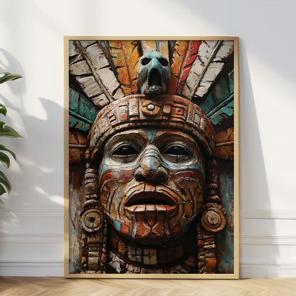 A large framed art print featuring a detailed Aztec-style face sculpture with a feathered headdress, leaning against a white wall on a light wood floor next to a green plant.