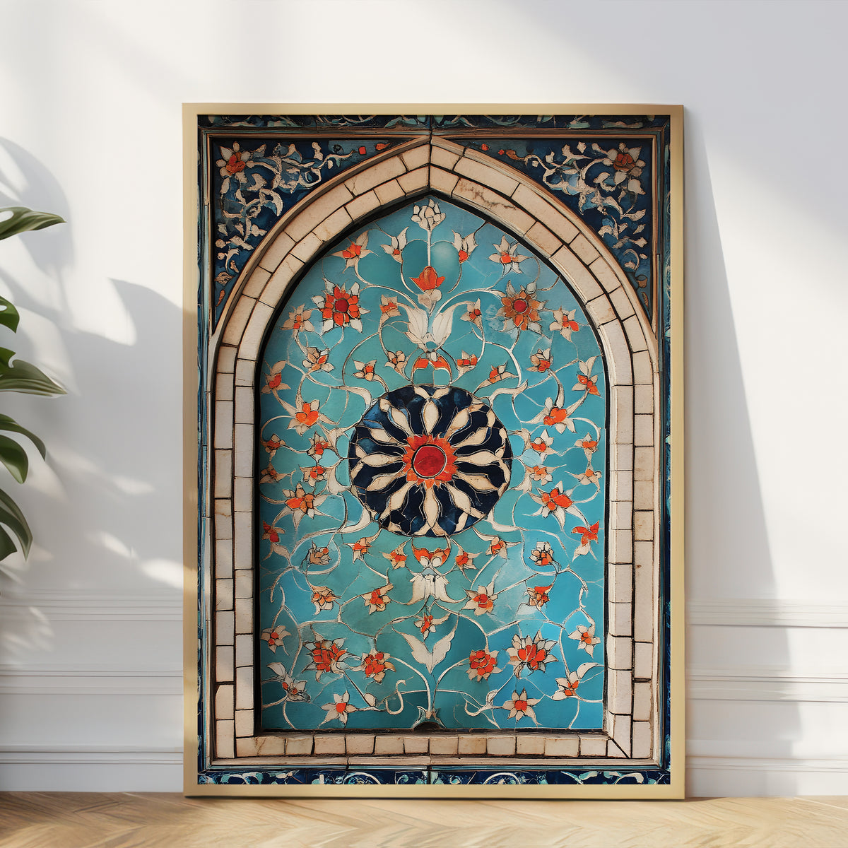 A large framed Islamic wall art piece featuring an intricate turquoise, gold, and orange floral pattern inside an arched frame, leaning against a white wall on a light wood floor.