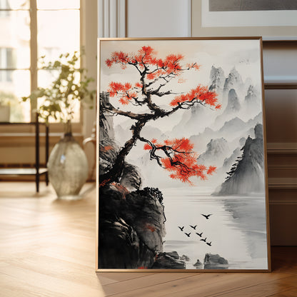 A framed vertical art print featuring a traditional Chinese landscape with a vibrant red tree, misty mountains, and a lake, displayed leaning against a wall on a wooden floor.