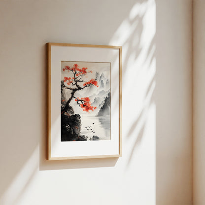 A framed vertical art print featuring a traditional East Asian landscape with a red-leafed tree, black mountains, and a river, hung on a warm beige wall with soft sunlight and leaf shadows.