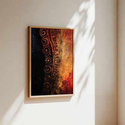A framed abstract art print hanging on a warm beige wall, featuring a vertical design with a black textured left side, a dark brown tribal pattern, and a fiery orange and red right side. The frame is light wood, and the scene is lit by soft natural shadows.