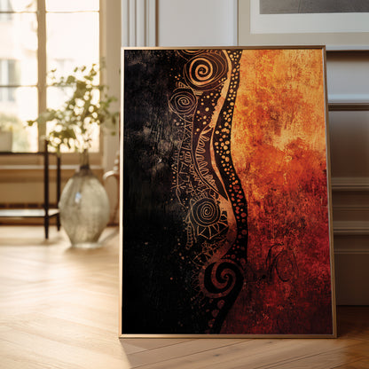 A framed abstract art print leaning against a wall on a light wood floor in a bright room. The artwork is split vertically into a dark black-and-brown patterned left side and a warm orange-red textured right side, with a thin light wood frame visible.