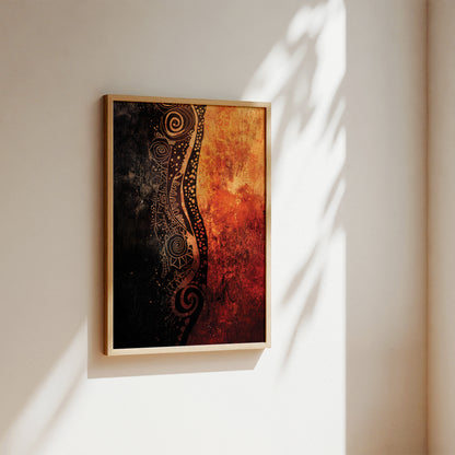 A framed abstract wall art print hanging on a warm off-white wall, with sunlight casting leafy shadows across the canvas and wall. The artwork features a vertical split design with a textured black and gold pattern on the left and a fiery orange and red gradient on the right, enclosed in a light wood frame.