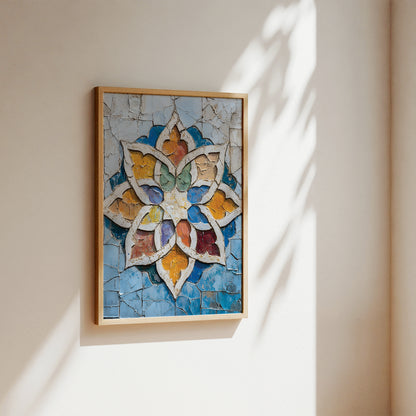 A framed mosaic wall art piece featuring a colorful geometric floral motif on a light blue background, hung on a beige wall with soft sunlight and leaf shadows.