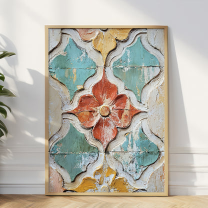 A framed wall art print leaning against a white wall on a light wood floor, showing a distressed geometric floral pattern in turquoise, cream, mustard yellow, and terracotta tones.
