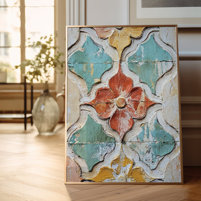 A framed square wall art print leaning against a wall on a light wood floor. The artwork shows a distressed, vintage-style floral and geometric pattern in turquoise, coral, mustard yellow, and off-white.