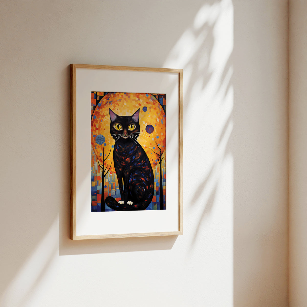 A framed art print featuring a stylized black cat in front of a glowing orange and yellow background, hung on a beige wall with soft sunlight and leaf shadows.