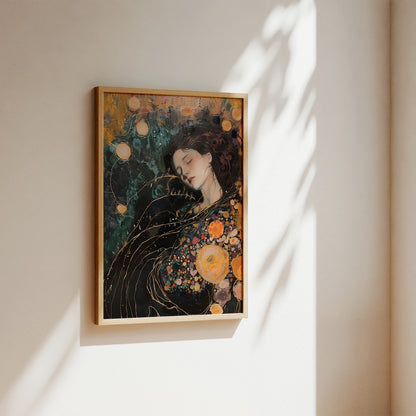 A framed art print featuring a stylized portrait of a woman with dark hair and orange floral details, hanging on a beige wall with soft sunlight and leaf shadows.