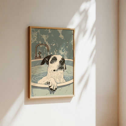 A framed art print depicting a black and white dog sitting in a bathtub, hanging on a beige wall with soft sunlight and leaf shadows cast across it.