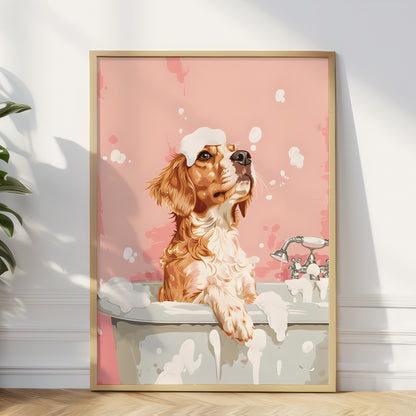 A framed art print depicting a wet golden-brown dog with soap bubbles in a bathtub, leaning against a white wall on a light wood floor next to a green plant.