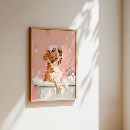 A framed art print featuring a cartoon-style dog in a bathtub against a pink background, hanging on a beige wall with soft sunlight and leaf shadows.
