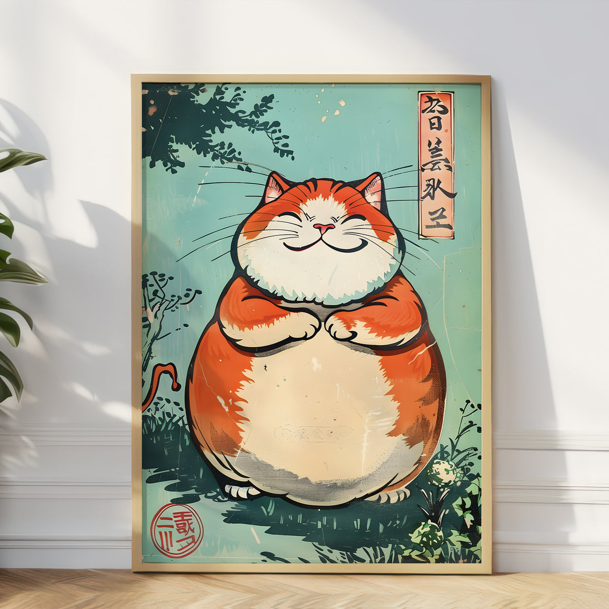 A framed art print featuring a cute, chubby orange and cream cat in a Japanese ukiyo-e style, leaning against a white wall on a light wood floor.