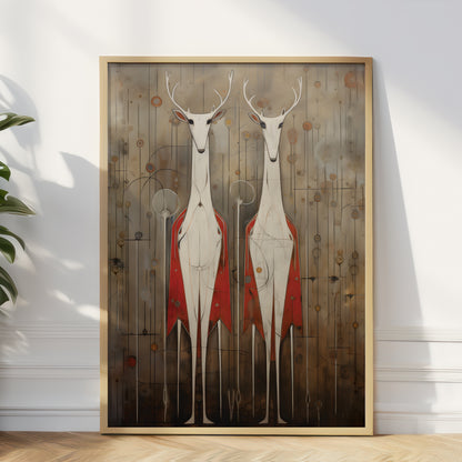 A framed vertical art print leaning against a white wall on a light wood floor, showing two stylized white deer with antlers and red draped cloaks on a brown abstract background. A plant and leaf shadows are visible at the left edge.