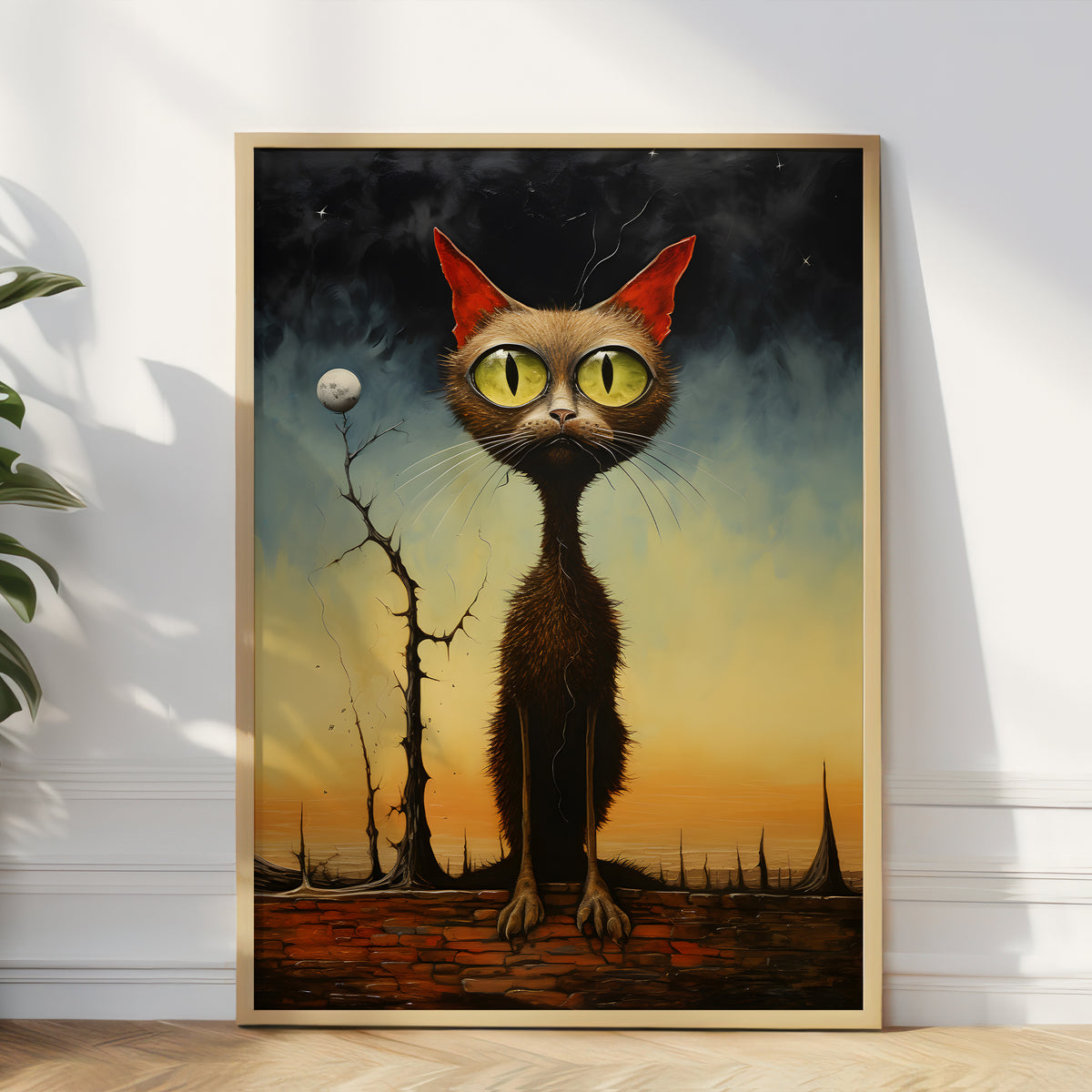A framed surreal art print featuring a tall brown cat with large yellow eyes and red ears, standing in a dark smoky sky above a barren landscape, leaning against a white wall in a room.