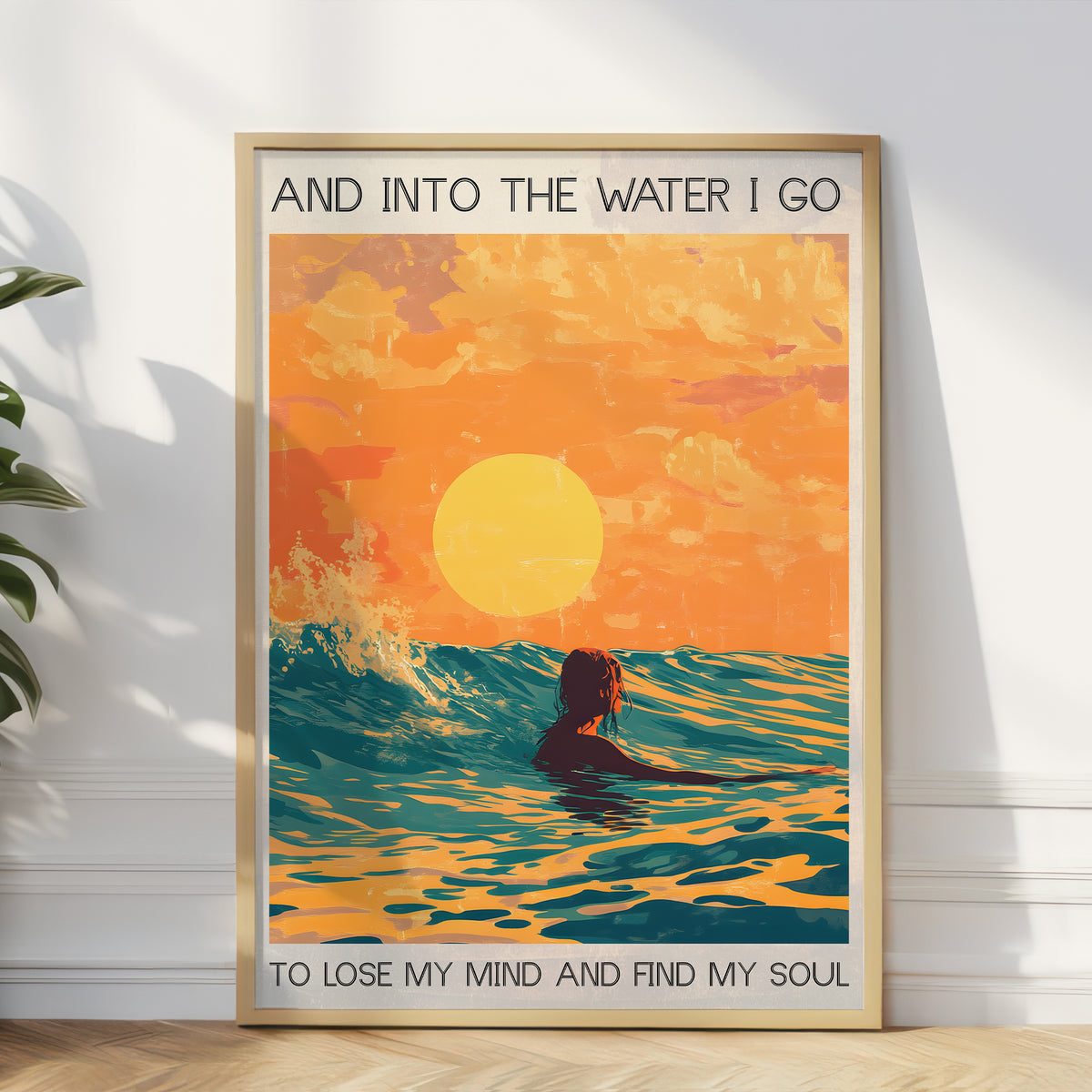Framed artwork of a person swimming in the water with a sunset background, text 'And into the water I go / To lose my mind and find my soul'.