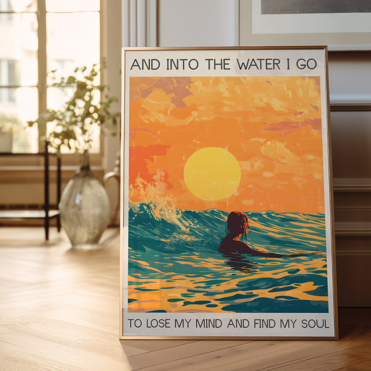 Framed poster with a sunset and person in water design, placed on a wooden floor.
