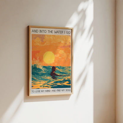 Framed artwork of a person in water with a sunset, titled 'And Into The Water I Go'.