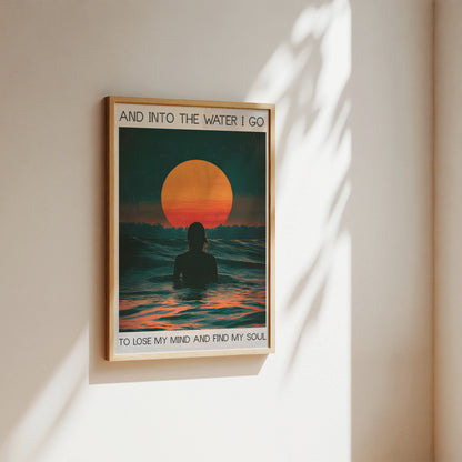 Framed artwork of a person in water with a sunset, on a wall.