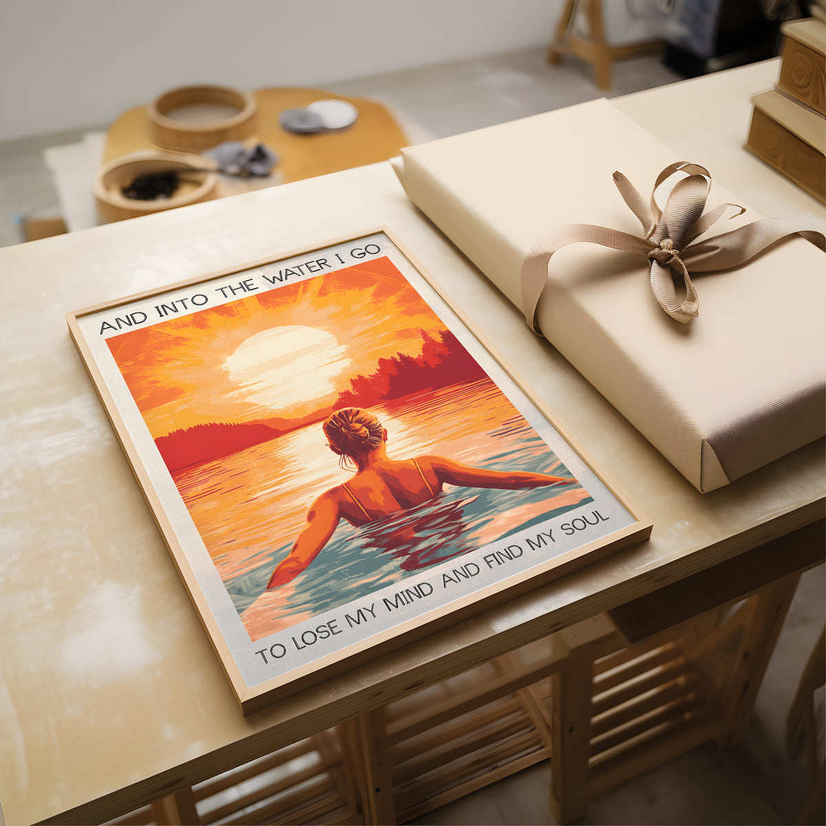 Poster of a person in water with text on a table next to a wrapped gift.
