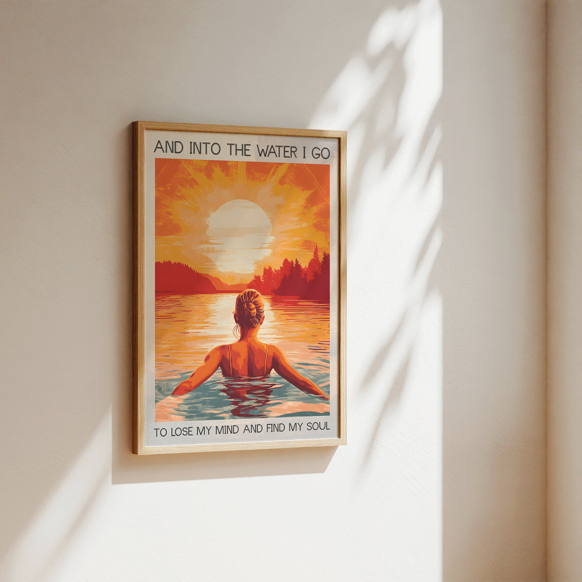 Framed artwork of a person in water with a sunset and text on a wall.