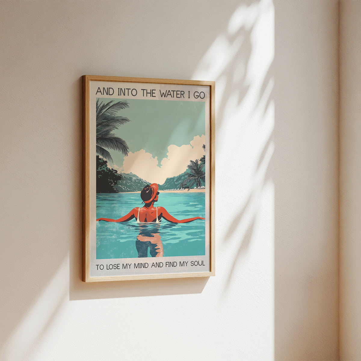 Framed artwork of a person in a pool with palm trees and text on a wall.