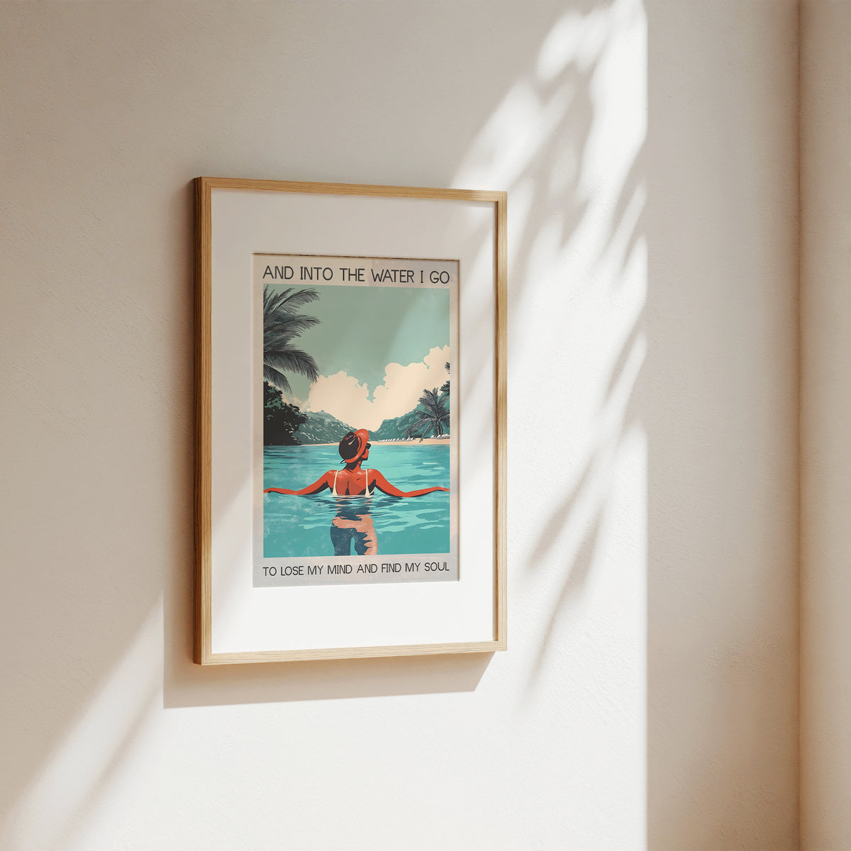 Framed artwork of a woman in a pool with palm trees and text on a beige wall.