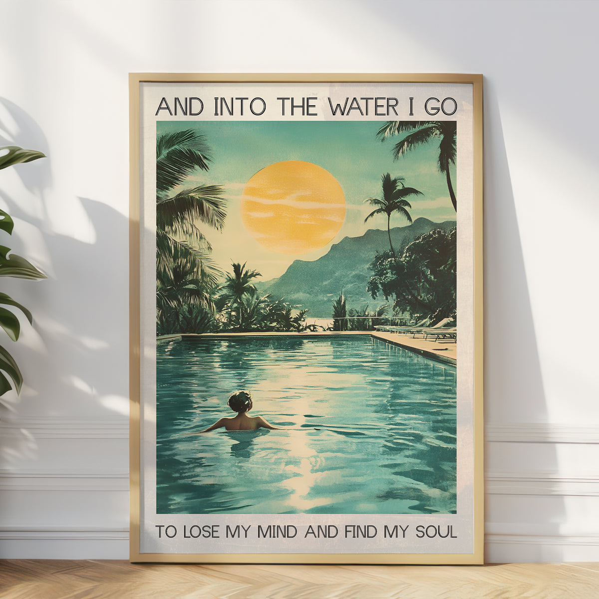 Framed poster of a tropical scene with a pool, palm trees, and a sunset, featuring text.