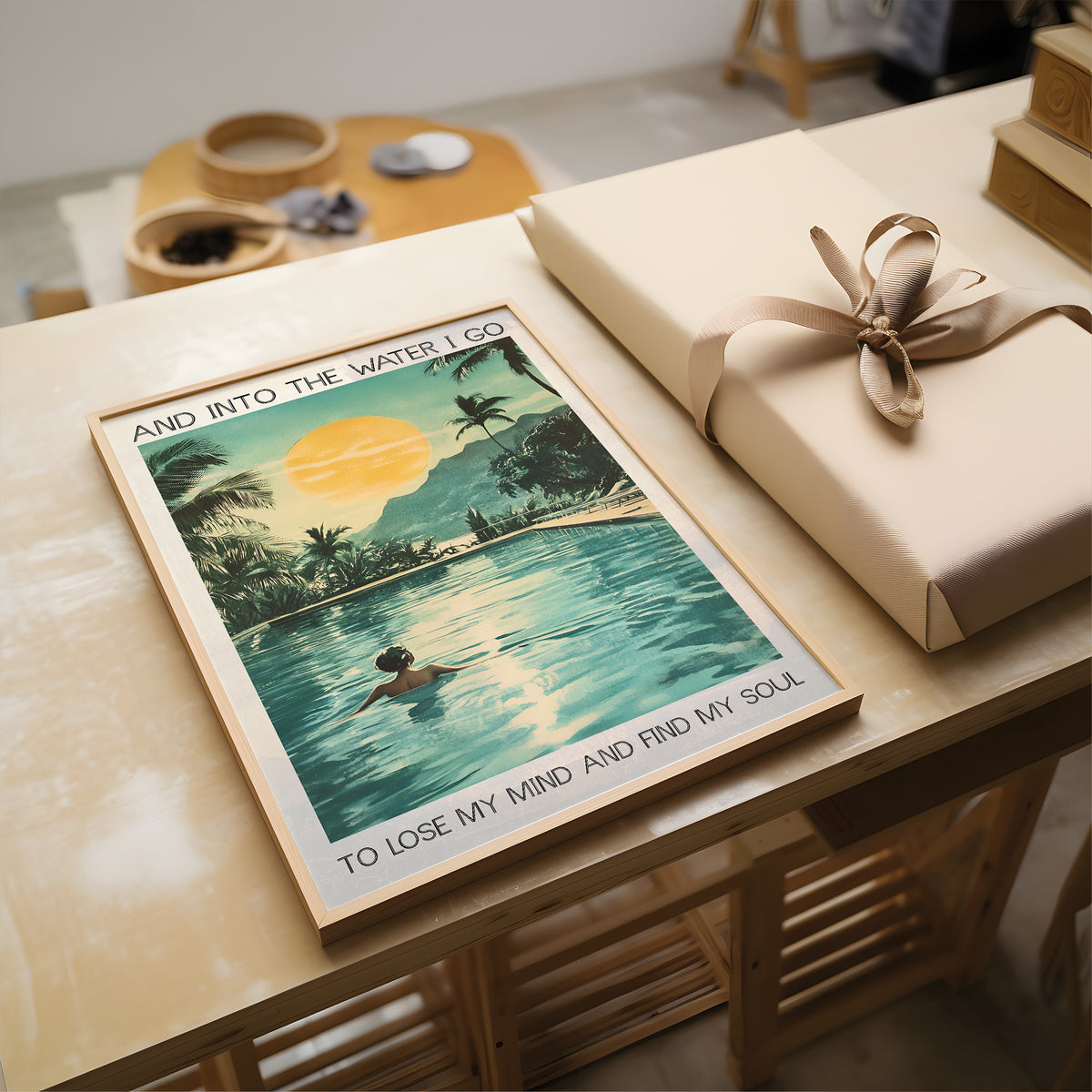 Poster of a swimmer in a pool with text, wrapped gift on a wooden table