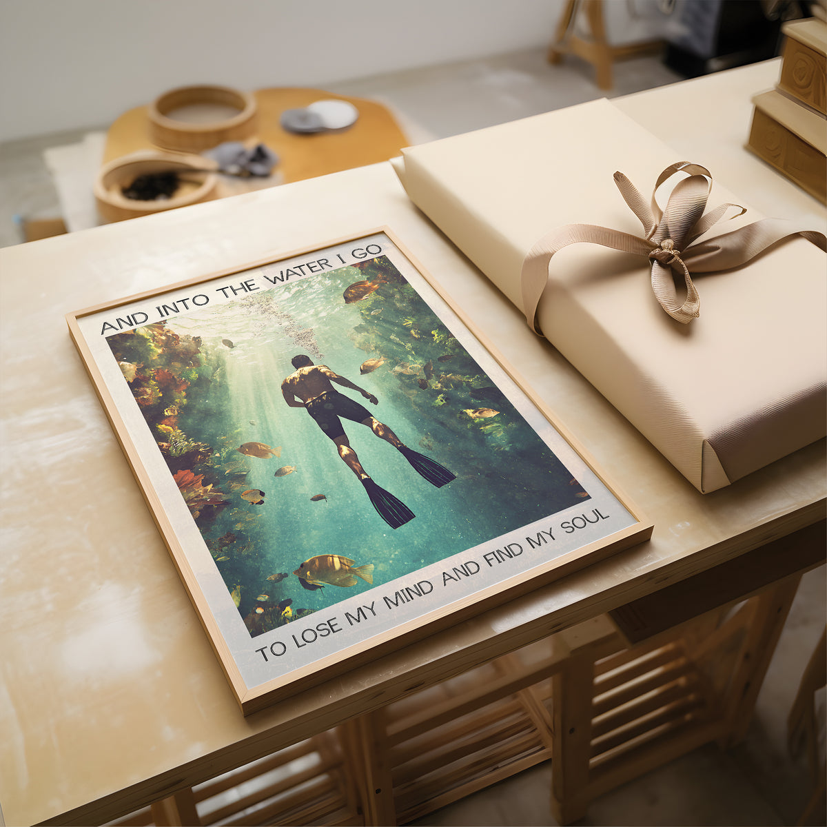 Poster of a diver with text on a table next to a wrapped gift
