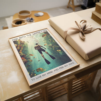 Poster of a diver with text on a table next to a wrapped gift