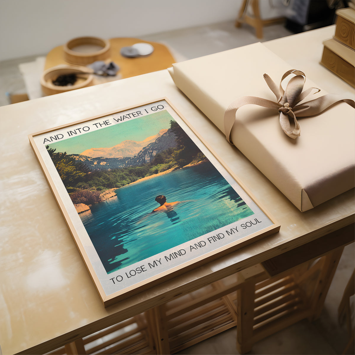 Poster of a person swimming with scenic text on a table with a wrapped gift.