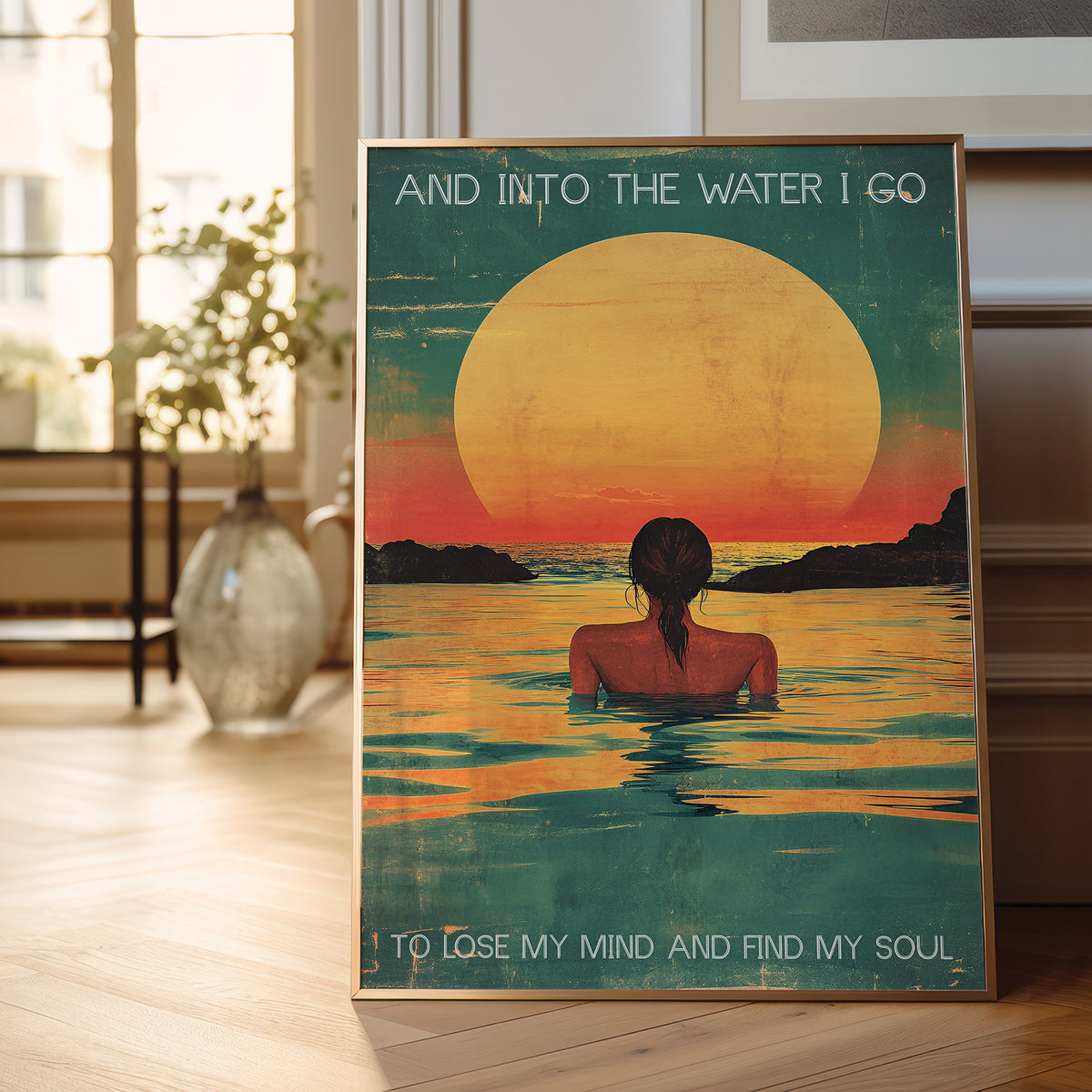 Poster of a woman in water with a sunset and text, placed on a wooden floor.