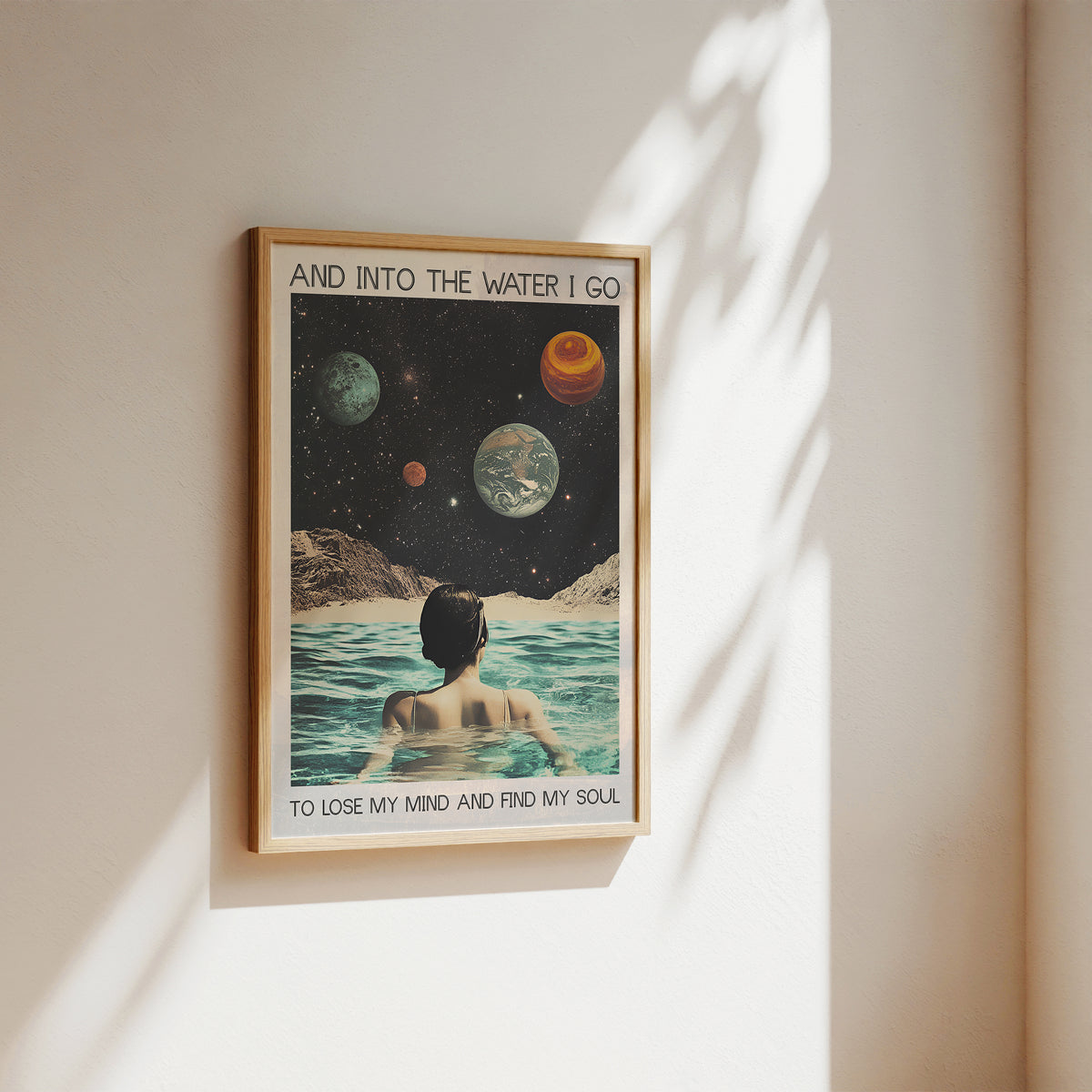 Framed poster with a space-themed design of a person in water, framed on a wall.
