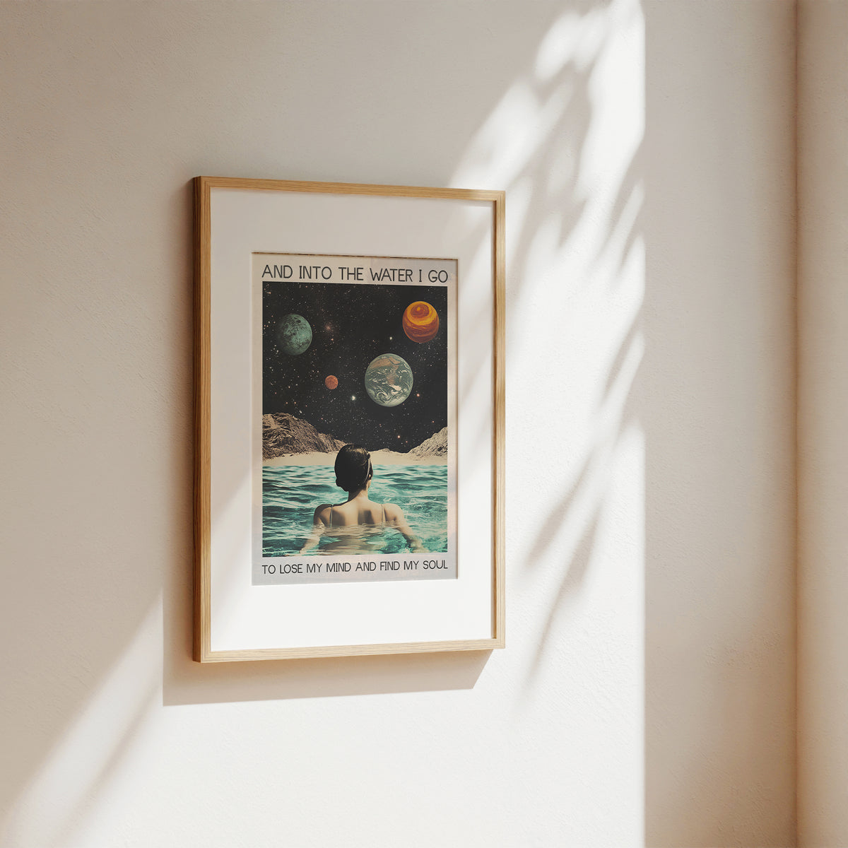 Framed poster of a person in water with celestial bodies on a wall.