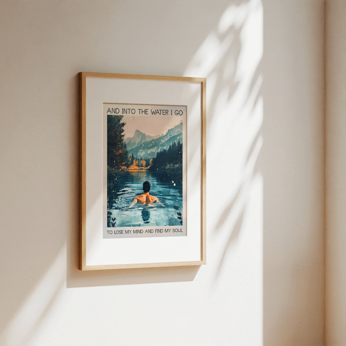 Framed artwork of a person in a lake with mountains, on a beige wall.