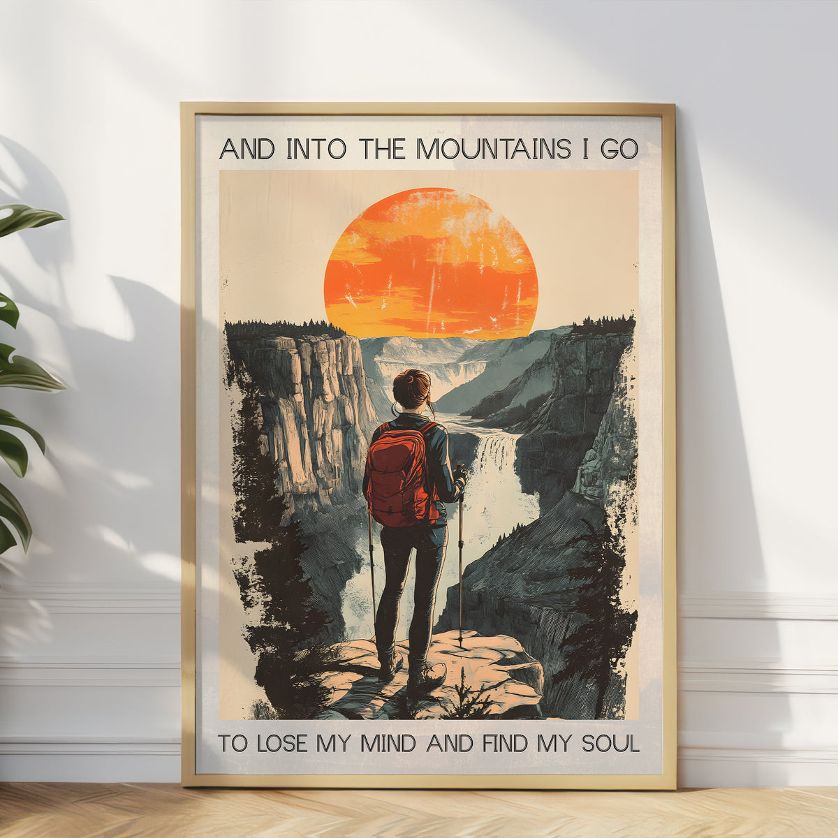 Framed poster of a person hiking with a sunset and mountain landscape, text 'And into the mountains I go to lose my mind and find my soul'.