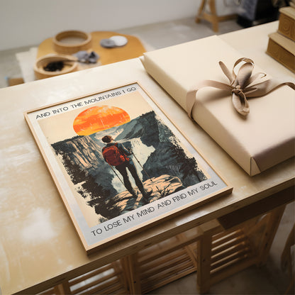 Poster of a person in a mountain scene with a wrapped gift on a wooden table.