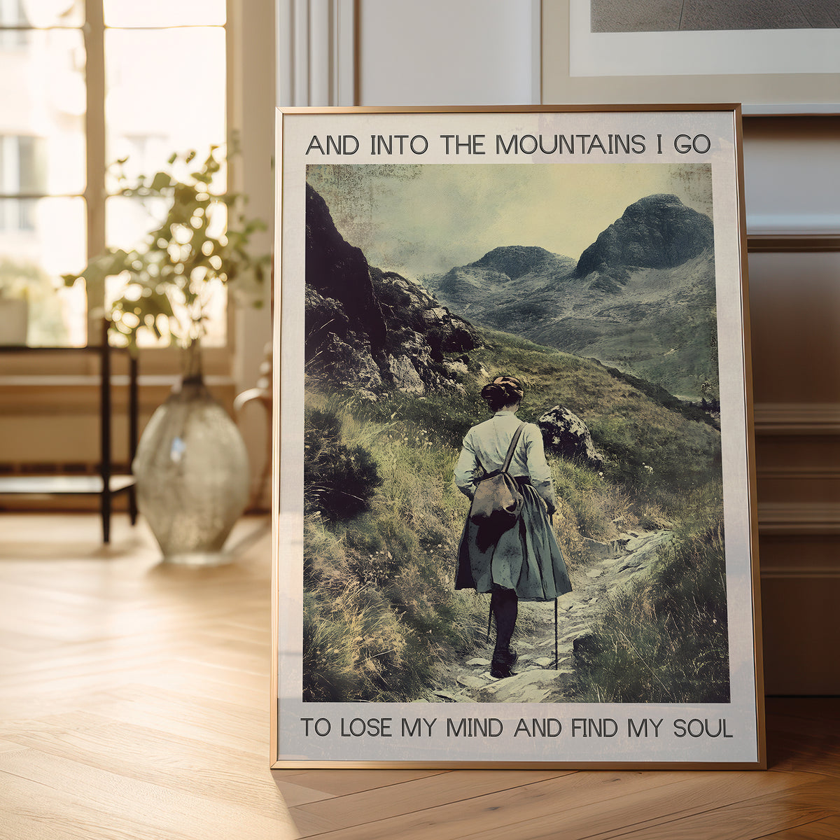 Framed poster of a person hiking with mountains in the background, displayed in a room.