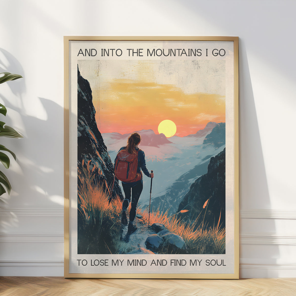 Framed poster of a person hiking with a sunset in the background, text 'And into the mountains I go to lose my mind and find my soul'.