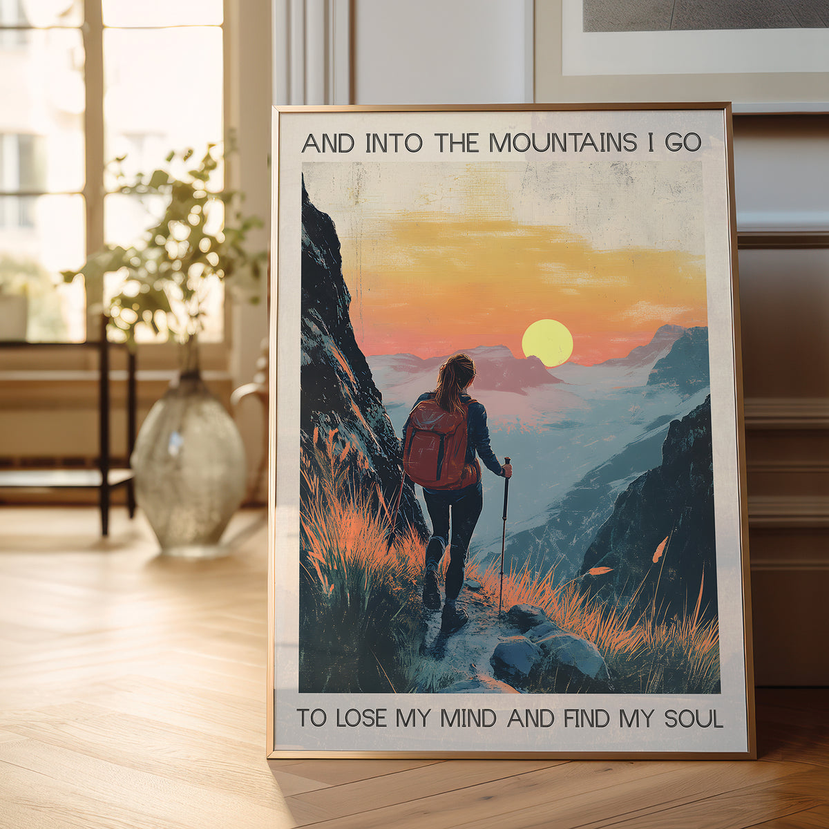 Framed poster of a person hiking with a sunset in the background, text 'And into the mountains I go to lose my mind and find my soul'.
