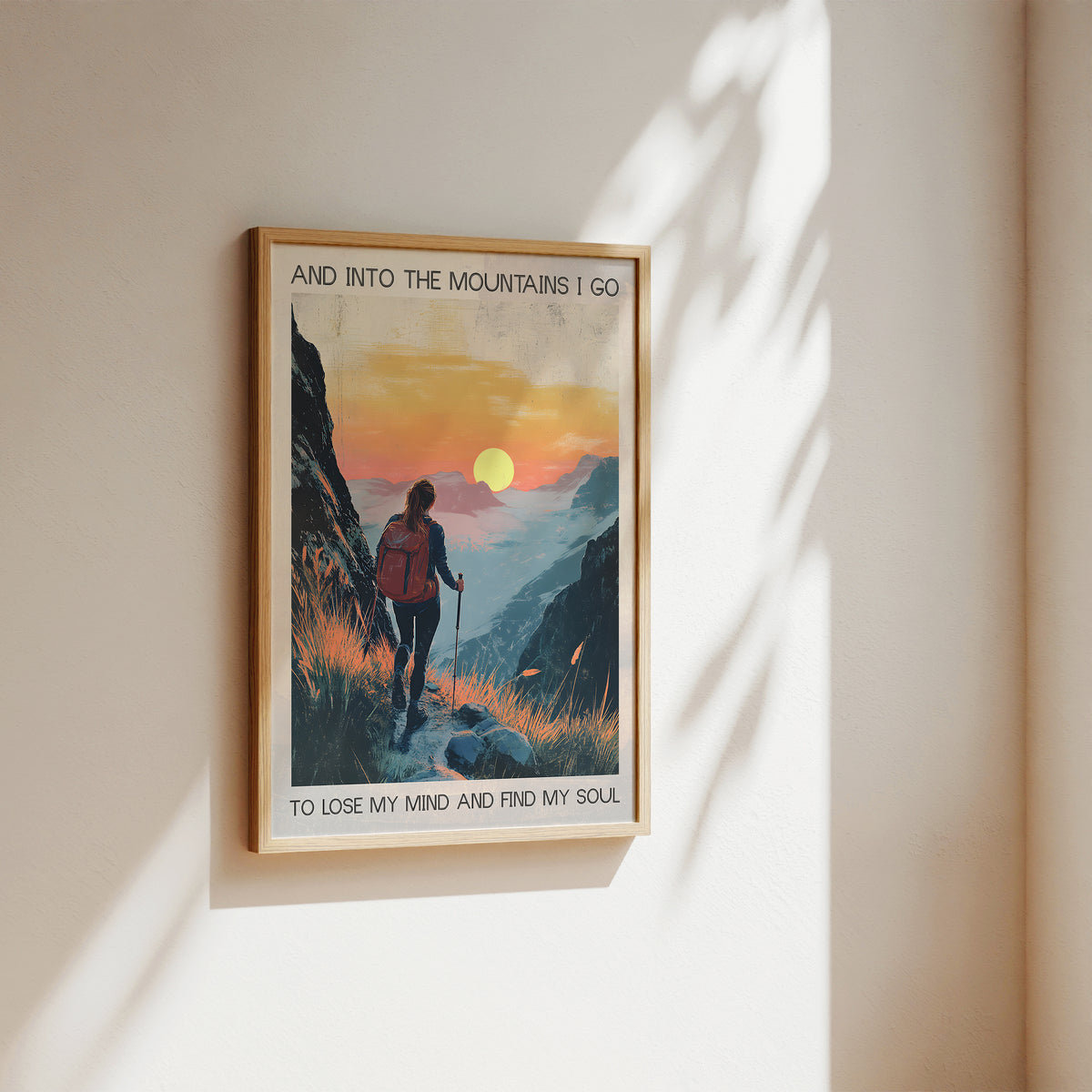 Framed poster of a mountain scene with a person hiking, featuring text on a wall.