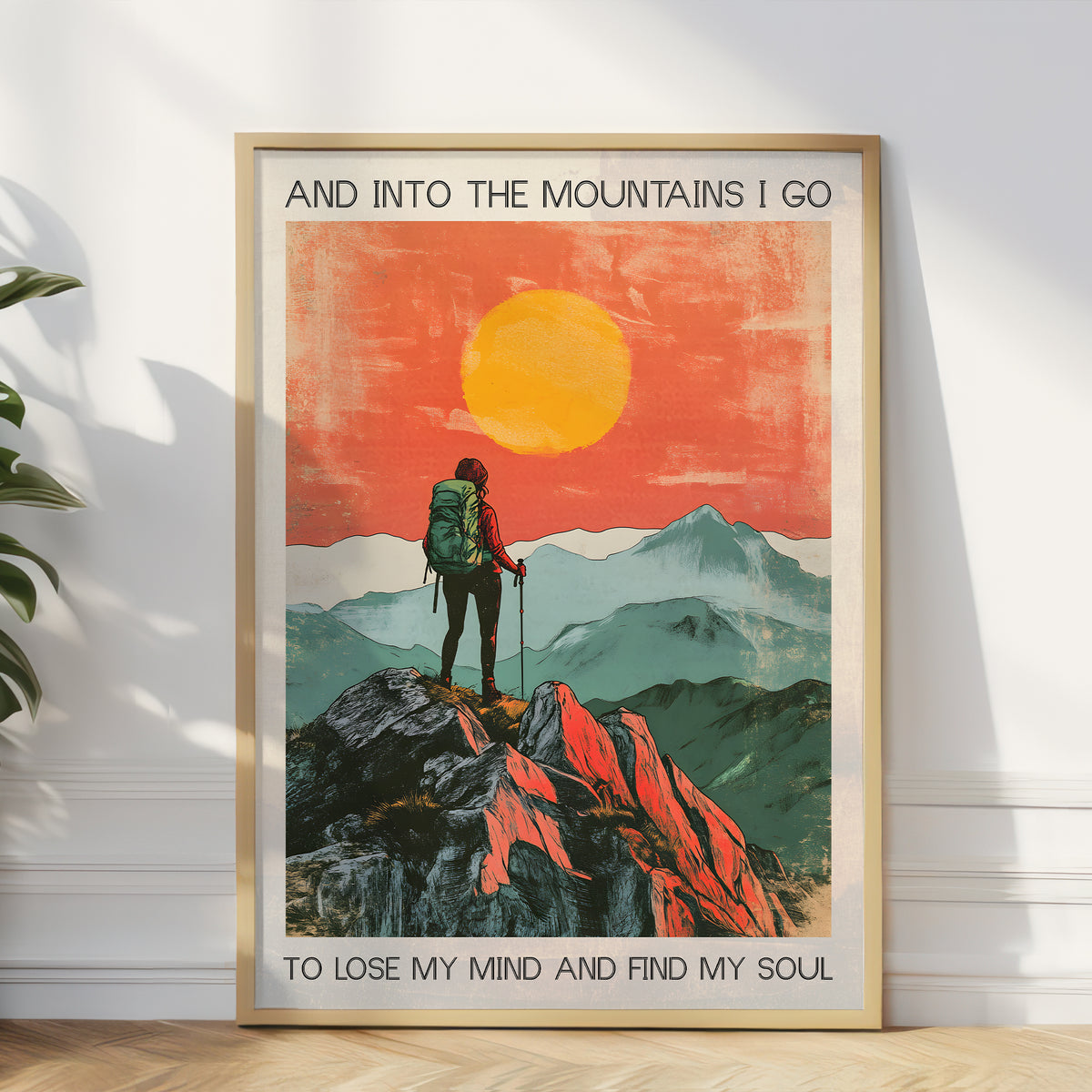 Framed poster of a mountain scene with a person and text on a white wall.