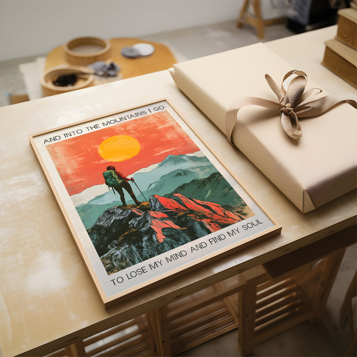 Poster of a hiker in the mountains with a gift on a wooden table.